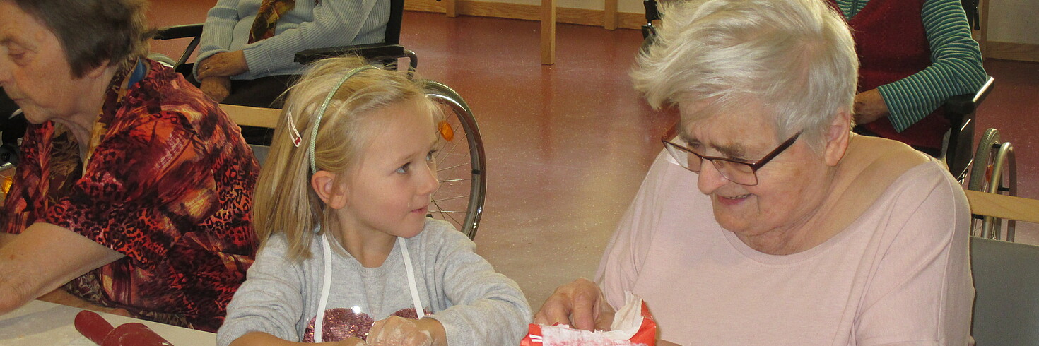 junges Mädchen und Seniorin formen Vanillekipferl